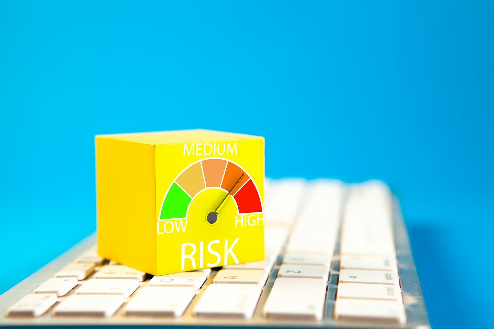 A cube showing a low-to-high risk gauge on a keyboard, representing whether follower tracker apps actually work safely