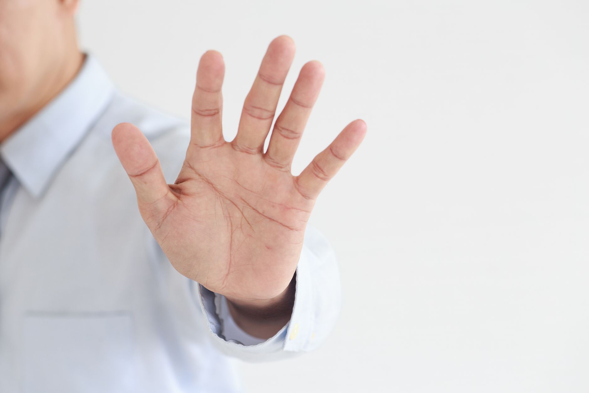 A hand raised in a stop gesture, representing blocking someone on Instagram and its effect on your follow status