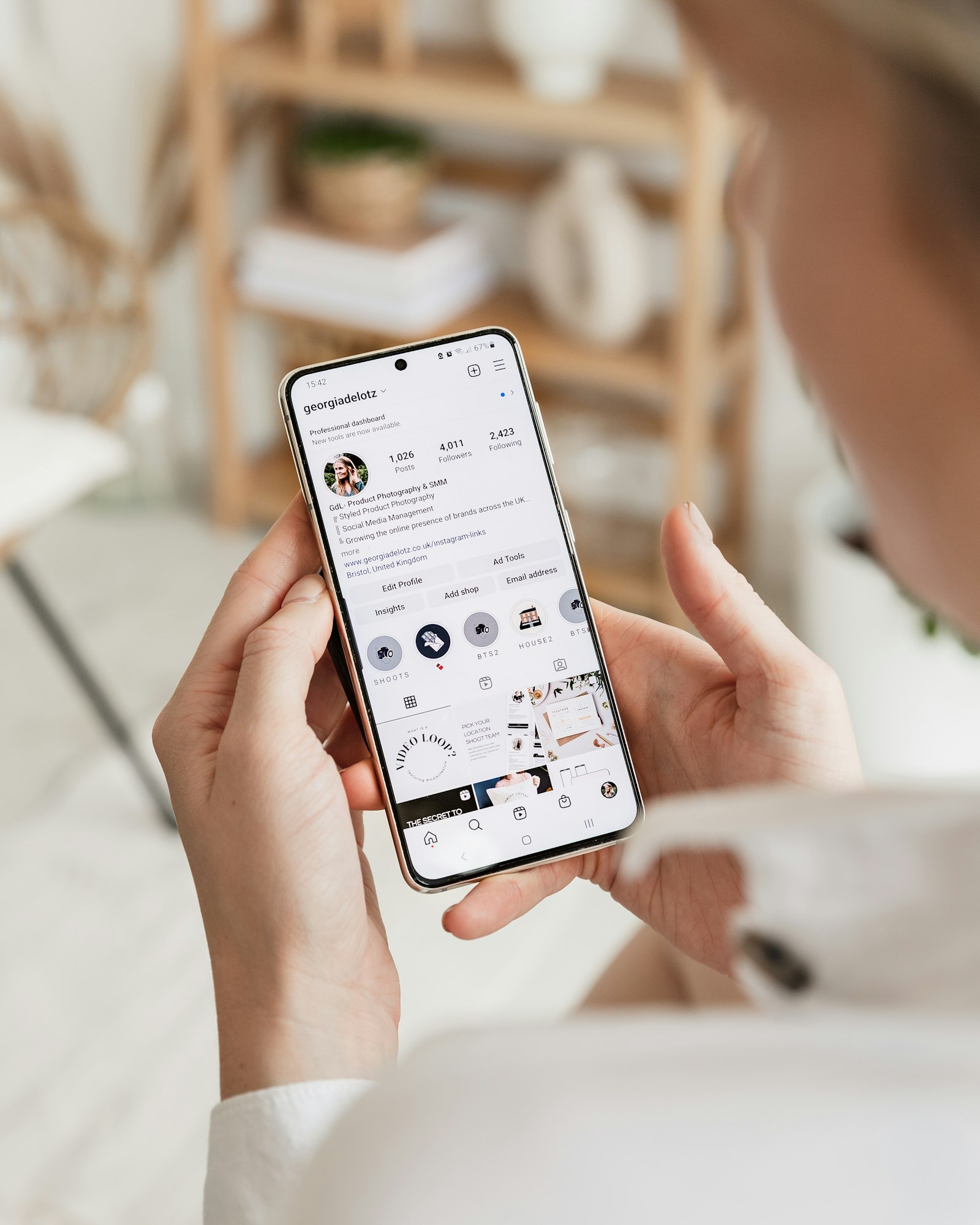 A person holding a phone showing an Instagram profile, representing requesting your Instagram data export