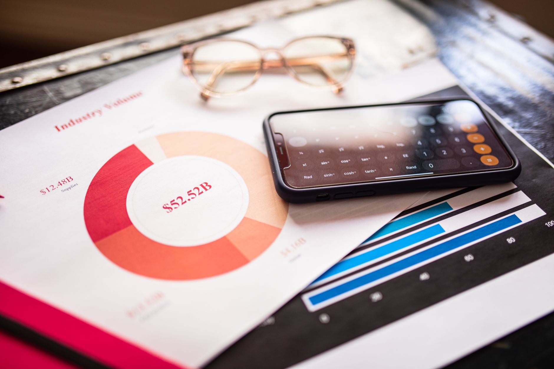A smartphone resting on printed charts and graphs, representing a mismatch between an Instagram follower count and a tracker
