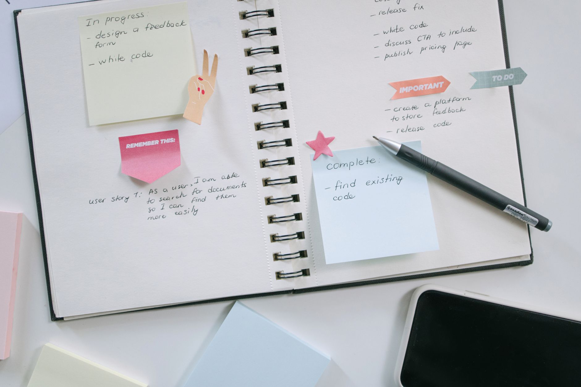 A notebook, smartphone, and sticky notes on a desk, representing sorting and organizing who you follow on Instagram