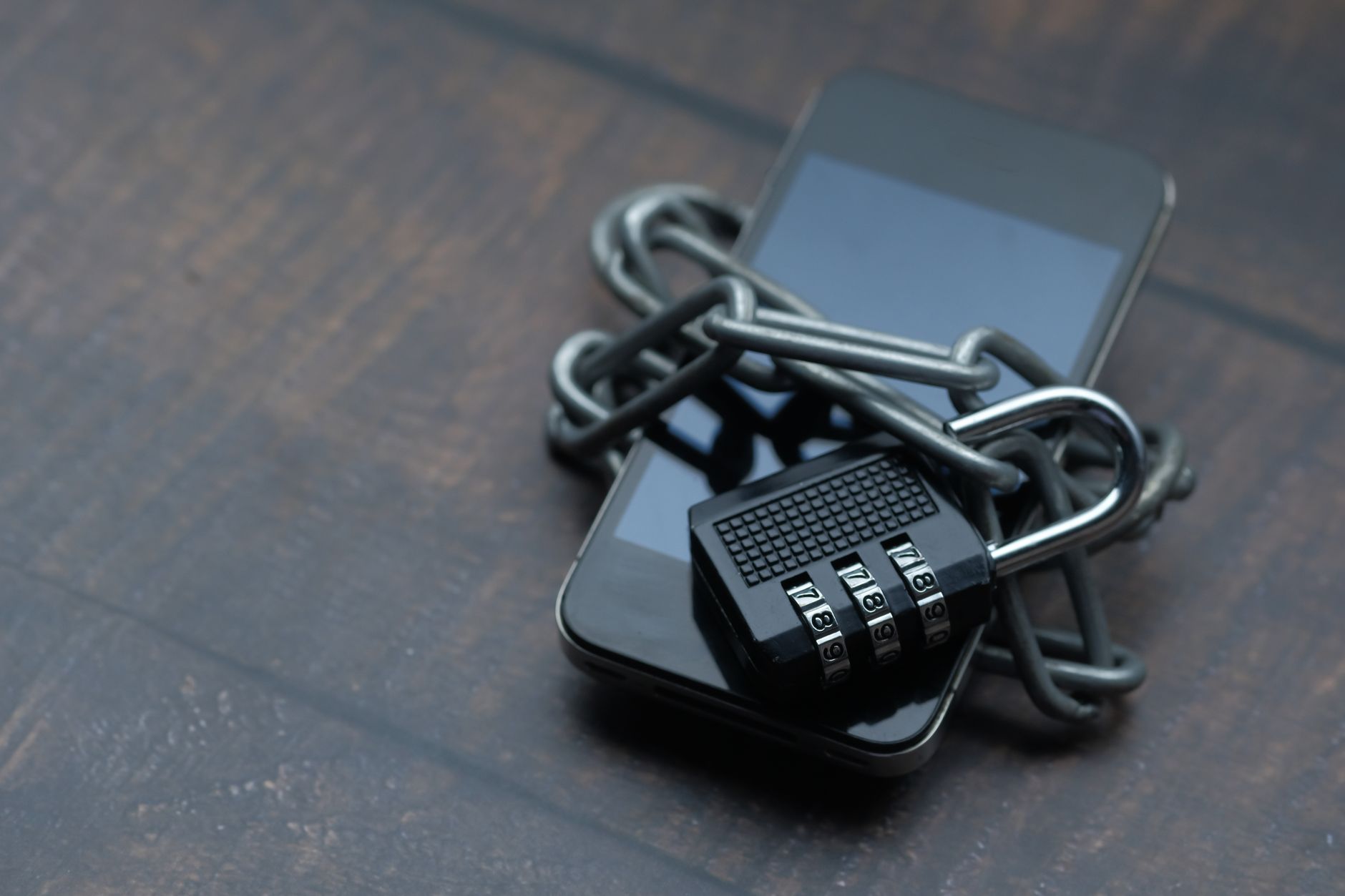 A smartphone wrapped in a chain with a padlock, representing checking who unfollowed you on a private Instagram account