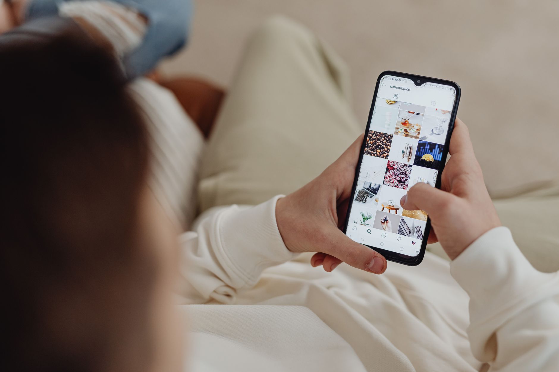 A person scrolling Instagram on a smartphone, representing checking whether cleaning up who you follow changes what you see and who sees you