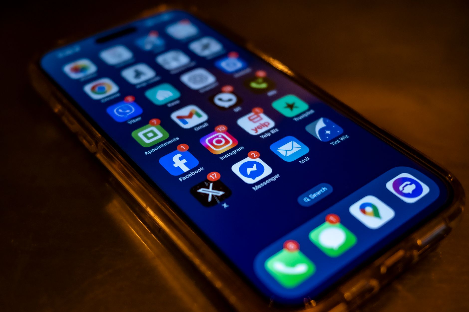 A smartphone screen showing social media app notifications in a dim setting, representing the alert Threads never sends for an unfollow