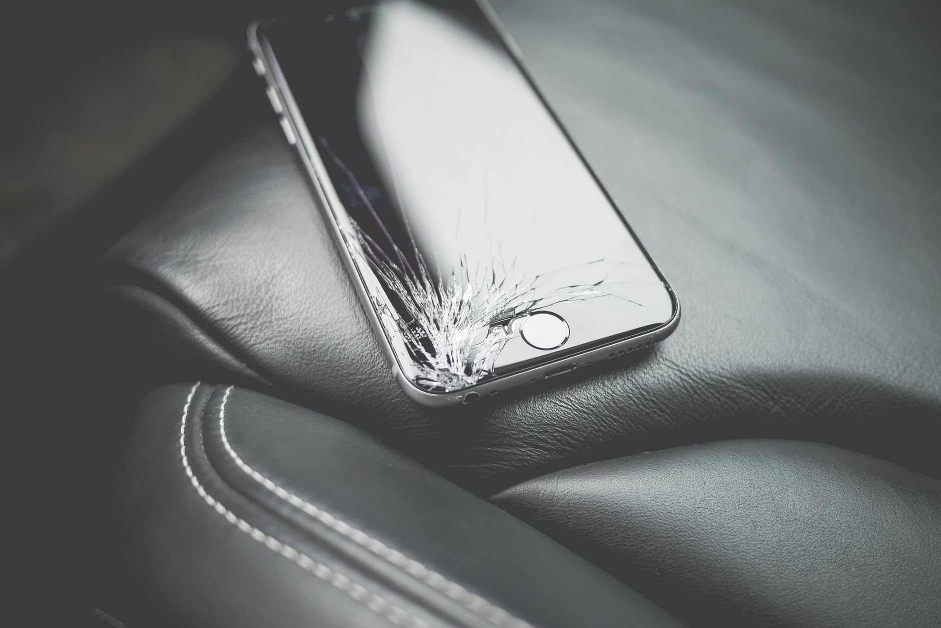A close-up of a smartphone with a cracked screen, representing an Instagram unfollow action that failed or reverted