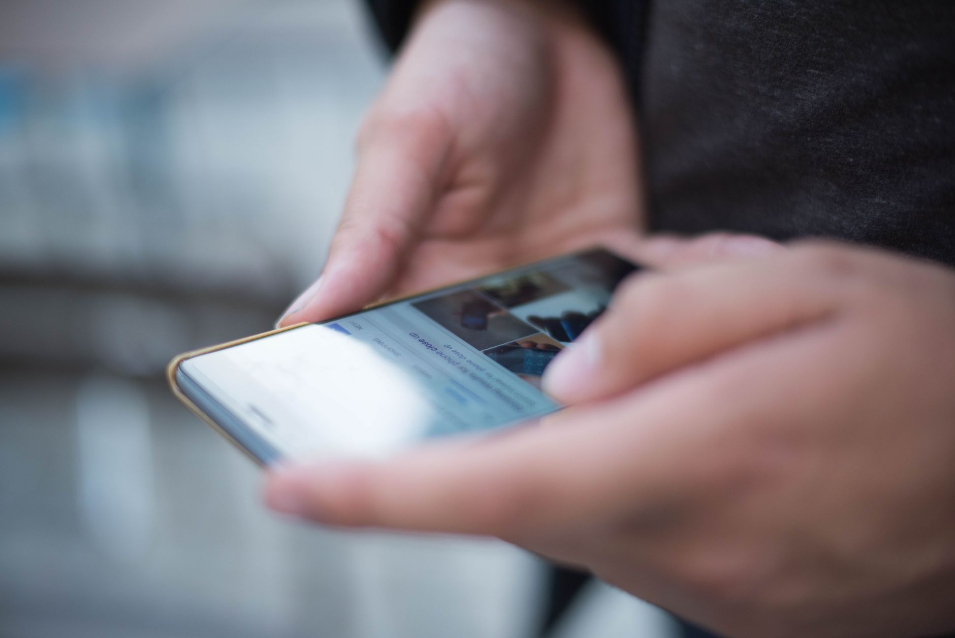 A close-up of hands using a smartphone touchscreen, representing the difference between unfollowing someone and removing them as a follower on Instagram