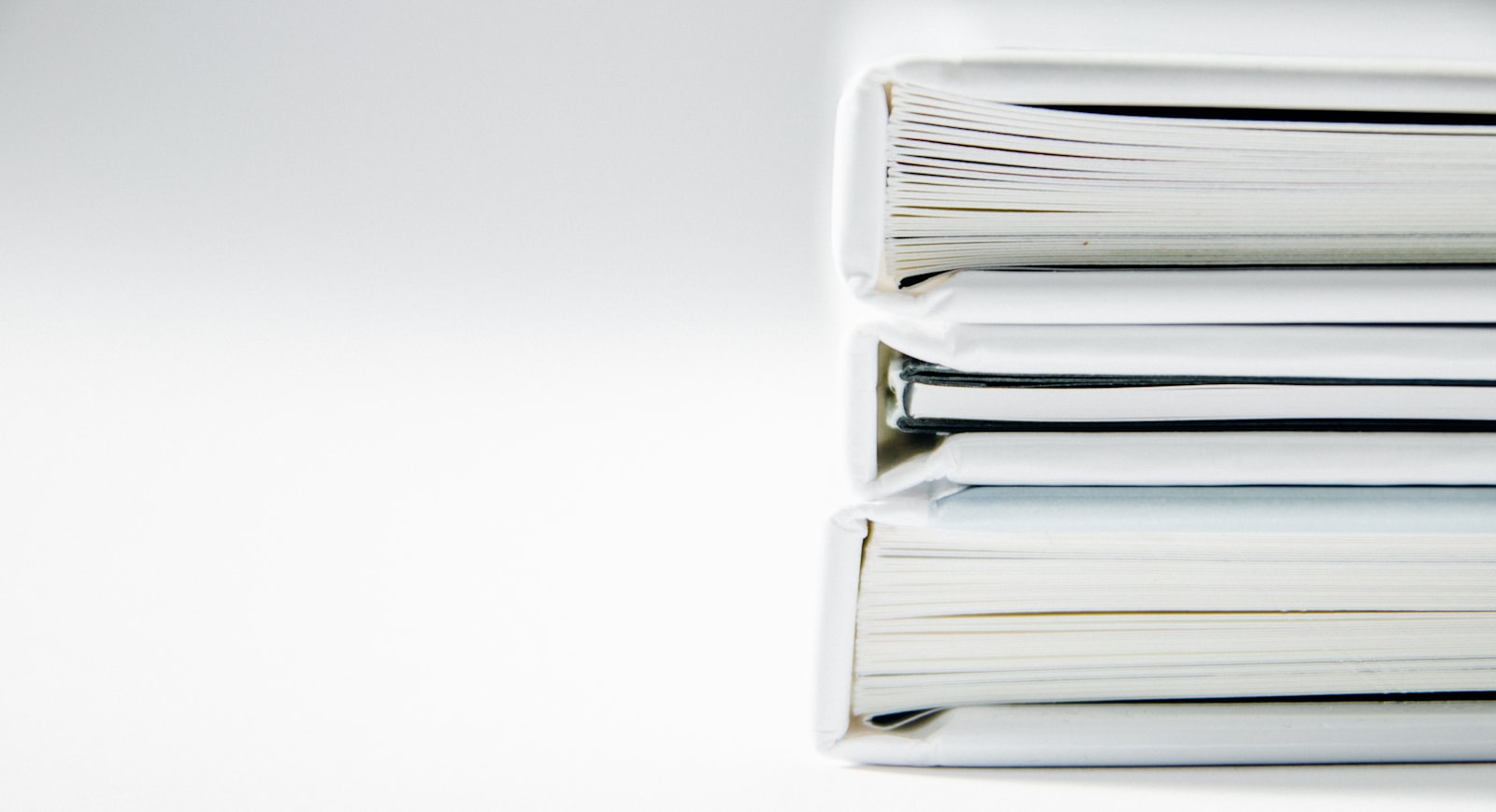 A stack of white binders and folders, representing the small set of files inside an Instagram data export ZIP